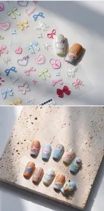 Macro shot of 3D embossed nail stickers featuring pastel bows and hearts on a stone base