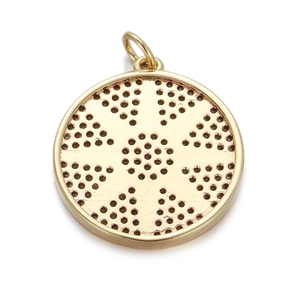 Macro detail of golden round pendant with sunburst openwork design and hanging loop