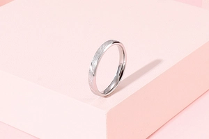 Detail of silver matte and polished stainless steel ring on a pink geometric stand