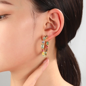 Gold plated C-shape hoop earrings with colorful zircon stones on a female model