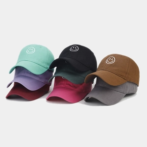 Detail view of colorful cotton baseball caps with embroidered smiley face designs