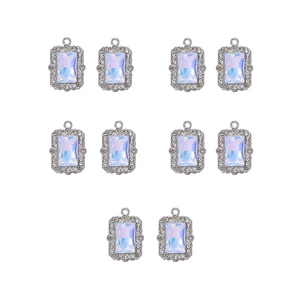 Detailed view of ten silver alloy pendants with opal crystals and rhinestone borders