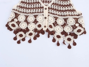 Detail of crochet v-neck vest with floral patterns and wooden buttons and tassels