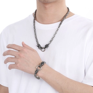 Close-up of vintage silver dragon head necklace and bracelet set with woven chain link