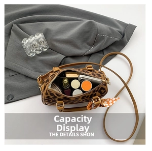 Top view of leopard print boston bag interior showcasing large capacity for makeup and phone