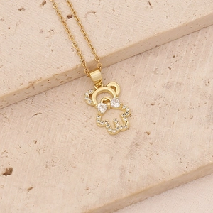 Macro view of gold plated bear pendant necklace with sparkling cubic zirconia on stone base