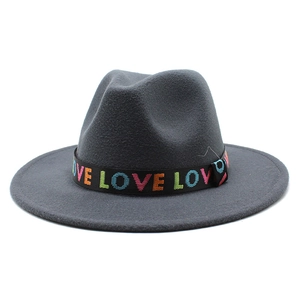 Détail d'un chapeau fedora gris foncé à large bord avec ruban brodé LOVE coloré