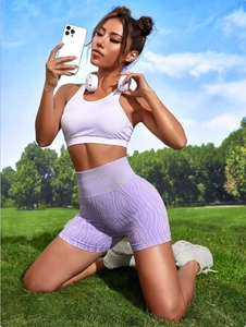 Close-up of lilac zebra pattern high-waist fitness shorts and white sports vest on grass