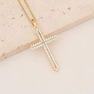 Detailed view of 18K gold plated cross pendant with micro-paved zircons on stone