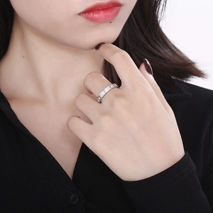 Polished silver titanium steel ring with roman numerals worn on female hand