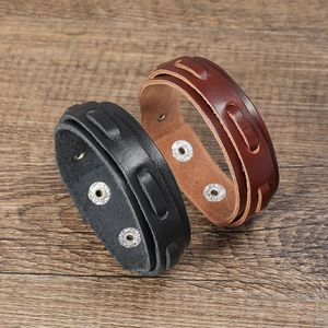 Detail of vintage multilayer leather bracelets in black and brown with metal snap buttons