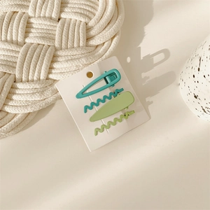 Close-up of four matte pastel green hair clips on display card with modern aesthetic