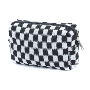Knitted checkerboard makeup bag in black and white with metal zipper closure