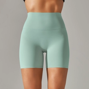 Detail showing high-waisted mint green seamless yoga shorts with abdomen support
