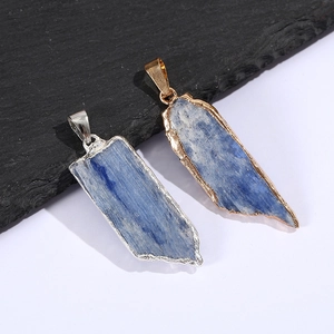 Macro detail of natural blue kyanite pendants with silver and gold metallic plated edges