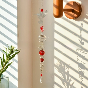 Detailed view of hummingbird metal charm and red crystal beads on the suncatcher