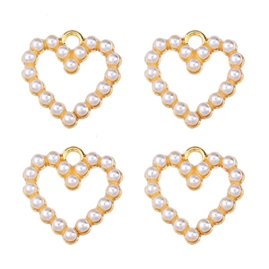 Detail of four heart-shaped pearl pendants with gold rings on a clean white background