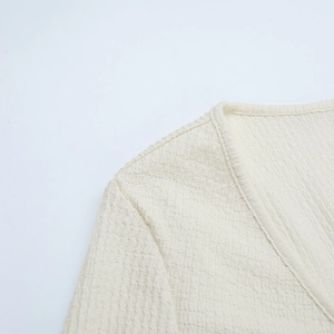 Détail de l'encolure en V et maille gaufrée texturée sur robe de vacances crème