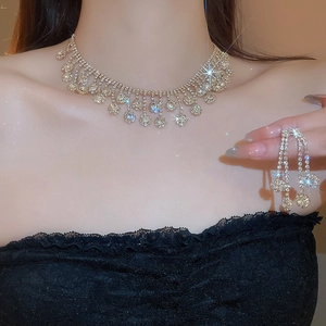 Detailed view of luxury zircon floral tassel necklace and earrings on a model