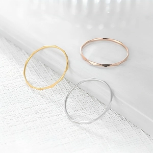Macro view of three 1mm minimalist faceted stackable rings in gold, silver and rose gold