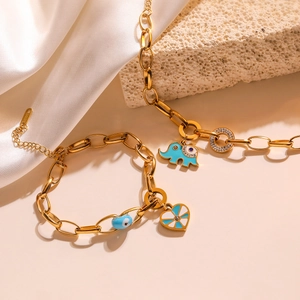 Close-up of gold titanium steel chain bracelet with blue enamel elephant and heart charms