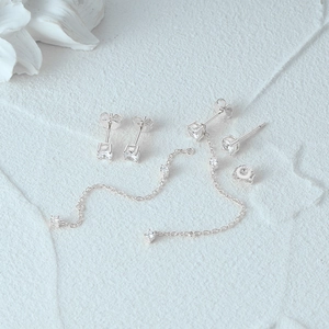 Detailed macro view of S925 sterling silver stud earrings and chain with cubic zirconia