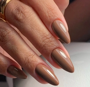 Détail d'ongles amande café brillant avec finition miroir haute qualité