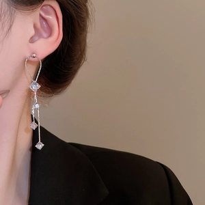 Longues boucles d'oreilles pendantes argentées avec zircons portées par un mannequin
