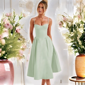 Détail d'une robe midi dos nu vert clair avec fond floral et coupe élégante à la taille