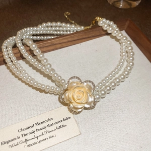 Detail of multi-layer pearl necklace with a rhinestone cream rose pendant in wood box