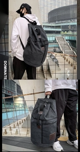 Macro detail of charcoal grey canvas backpack with brown leather patch and thick straps