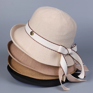 Close-up of stacked woven sun hats showing intricate knit texture and ribbon details