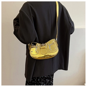 Rear view of model wearing a metallic gold crossbody bag with studs and zipper detail