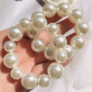 Close-up of elegant oversized faux pearl elastic hair ties with a smooth glossy finish