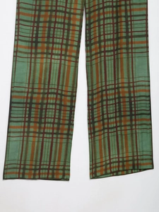 Vue détaillée du pantalon de costume à carreaux verts avec motif rouge foncé et marron