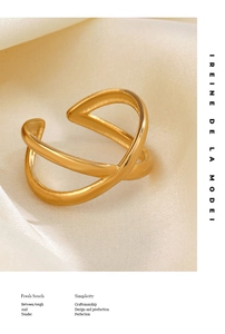 Macro shot of 18K gold plated X-cross ring on cream silk fabric texture