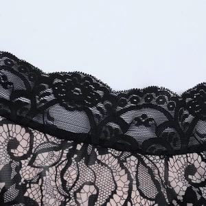 Detail of floral black lace top with sheer beige lining and delicate scalloped edge