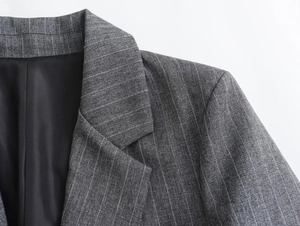 Detail shot of notched lapel and shoulder tailoring on a grey pinstripe blazer