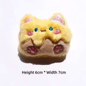 Dettaglio di ciondolo gatto in peluche giallo con ricami, misura H: 6cm * L: 7cm