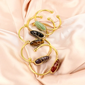 Set of five handmade gold-plated wire wrapped bangles with oval natural crystal gemstones
