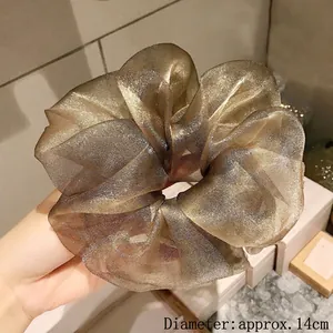 Detail shot showing 14cm diameter of champagne gold oversized organza scrunchie