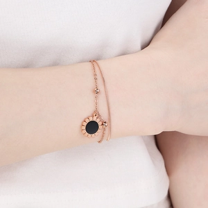 Gros plan d'un bracelet tournesol double couche en or rose avec pierre oeil-de-chat