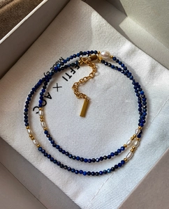 Gros plan du collier fait main en perles d'eau douce et lapis-lazuli dans un coffret cadeau