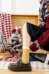 Detailed close-up of yellow plush Christmas socks with white star patterns and fleece texture