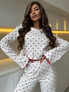 Detail of red heart prints on white ribbed knit pajama set with ruffle lettuce edges