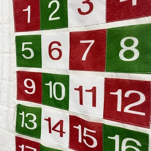 Christmas advent calendar with 24 numbered pockets made of red, green, and white felt fabric