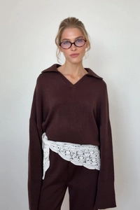 Details des dunkelbraunen Stricksets mit V-Ausschnitt Pullover und weißem Spitzenband