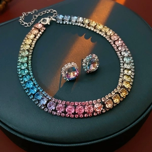 Close-up of sparkling rainbow crystal necklace and earring set on dark display box