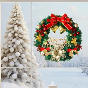 Detailed view of festive Christmas wreath with golden bells and red bow on a window