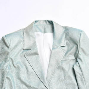Détail du revers et de l'épaule d'un blazer bleu clair pailleté aux reflets métalliques